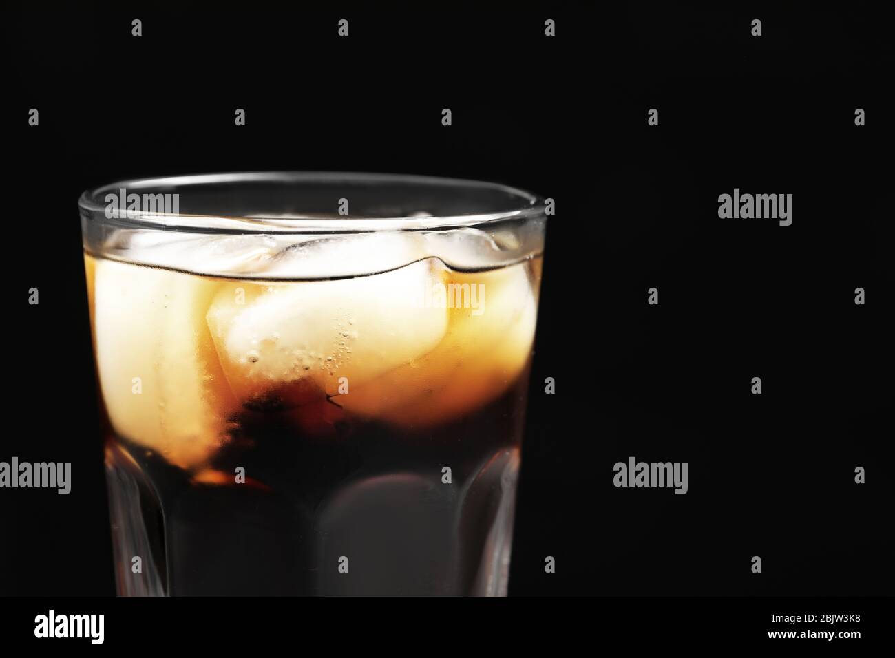 Glass of refreshing cola with ice on black background, closeup Stock ...