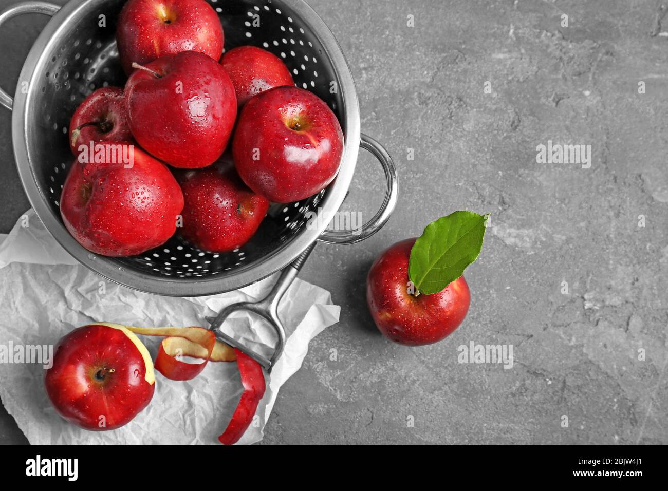 Colander with ripe red apples and peeled fruit on table Stock Photo - Alamy
