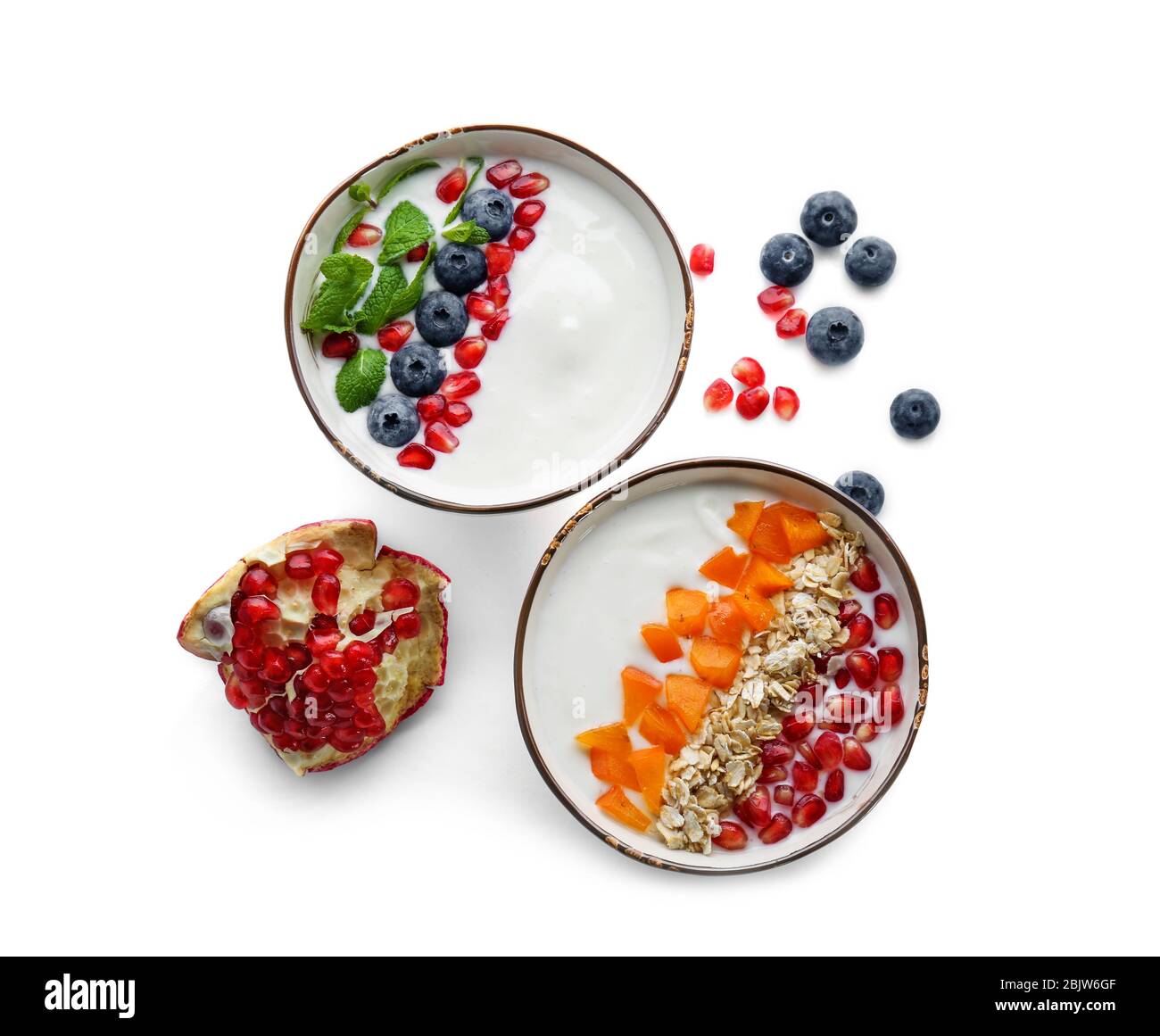 Yogurt with fruits in dishes on white background Stock Photo