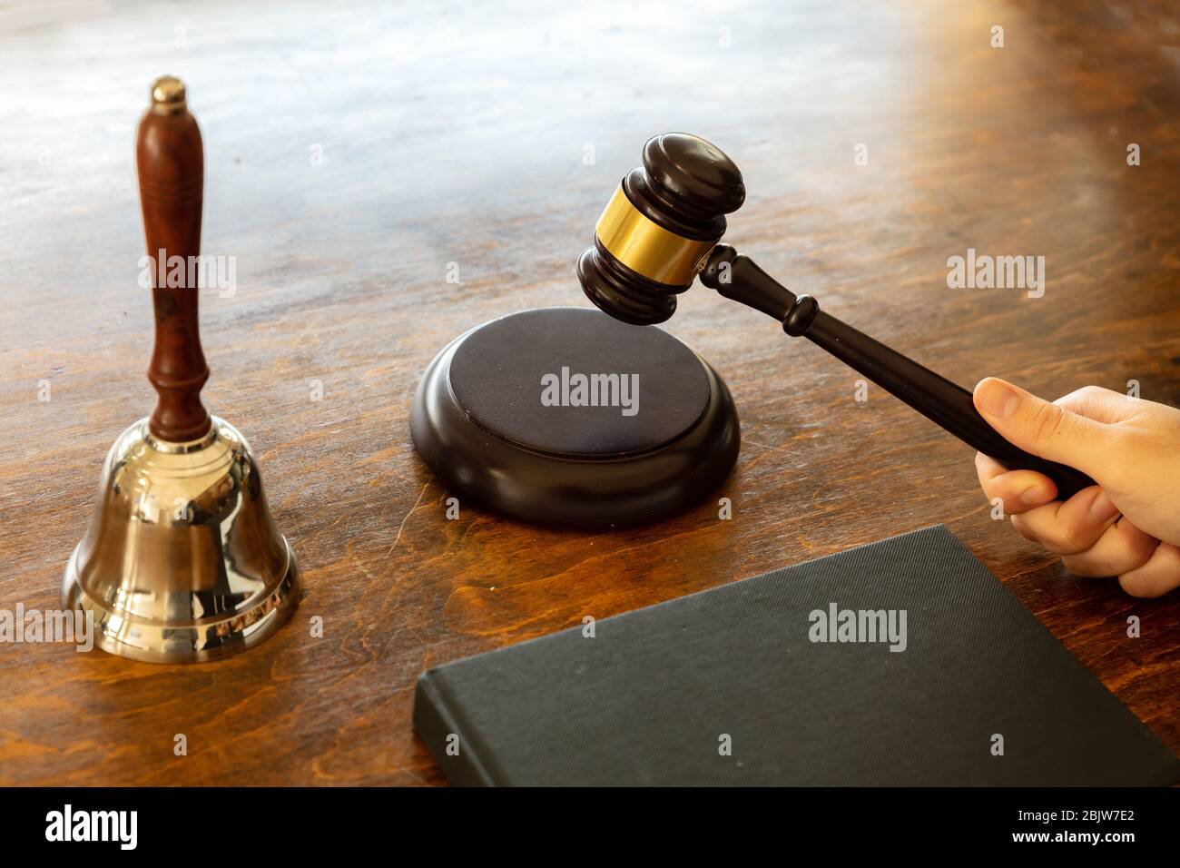 Judge holding a gavel on wooden courthouse desk background. Law theme. Stock Photo