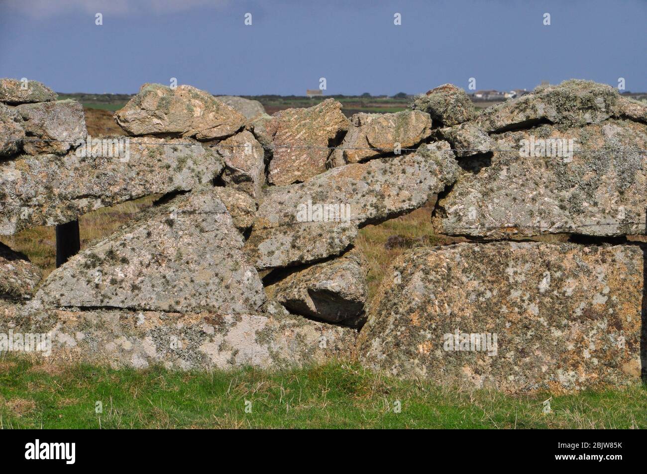 Large Granite boulders create a long lasting dry stone wall.The wall is Lichen and moss covered large stones with holes.Cornwall;UK;England Stock Photo
