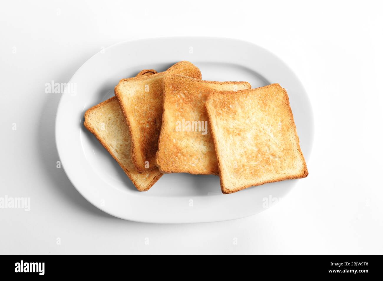 Plate with toasted bread on white background Stock Photo - Alamy