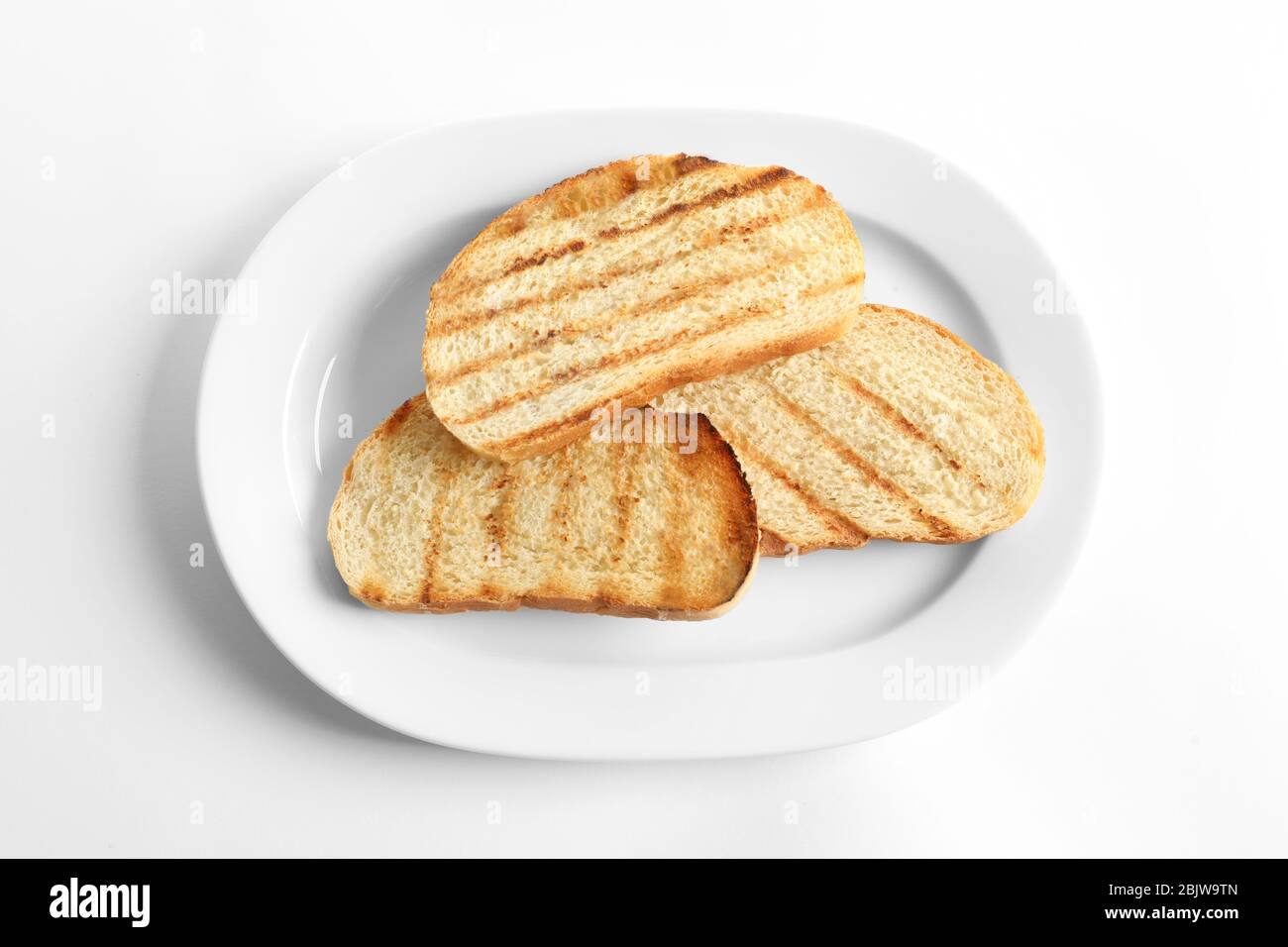 Plate with toasted bread on white background Stock Photo - Alamy
