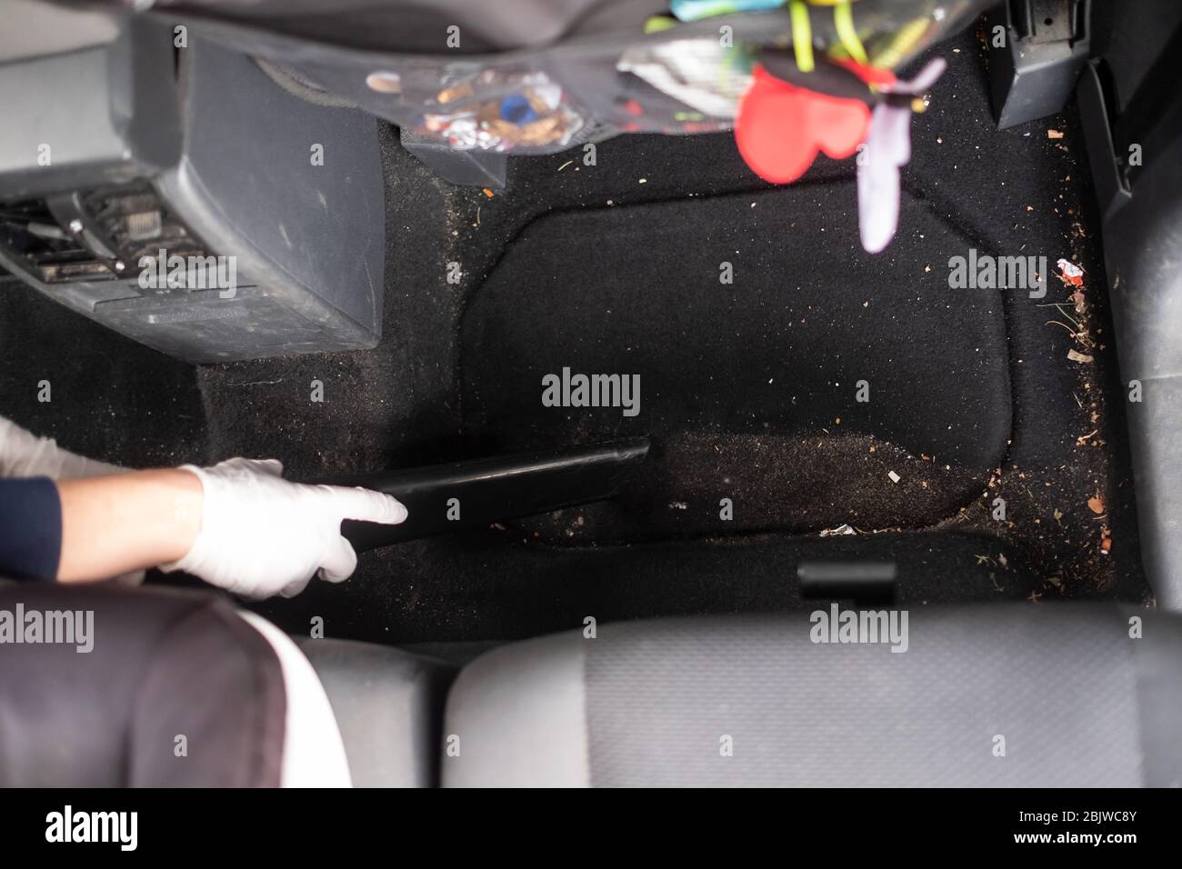 Female hands using vacuum cleaner to clean a car. Top view Stock Photo
