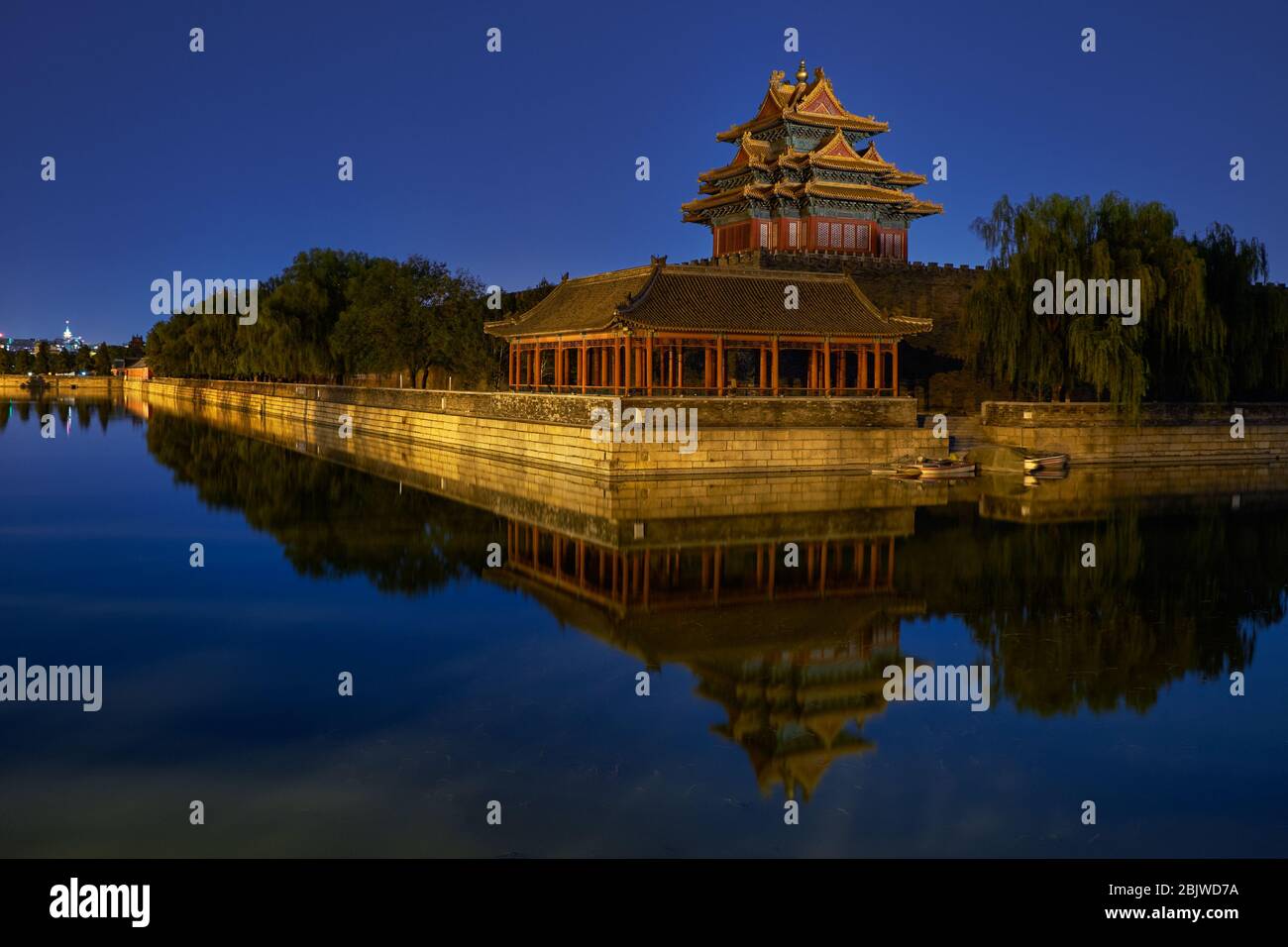 Northwestern tower of the Forbidden City Palace Museum in Beijing, China, reflecting in the water moat at night Stock Photo