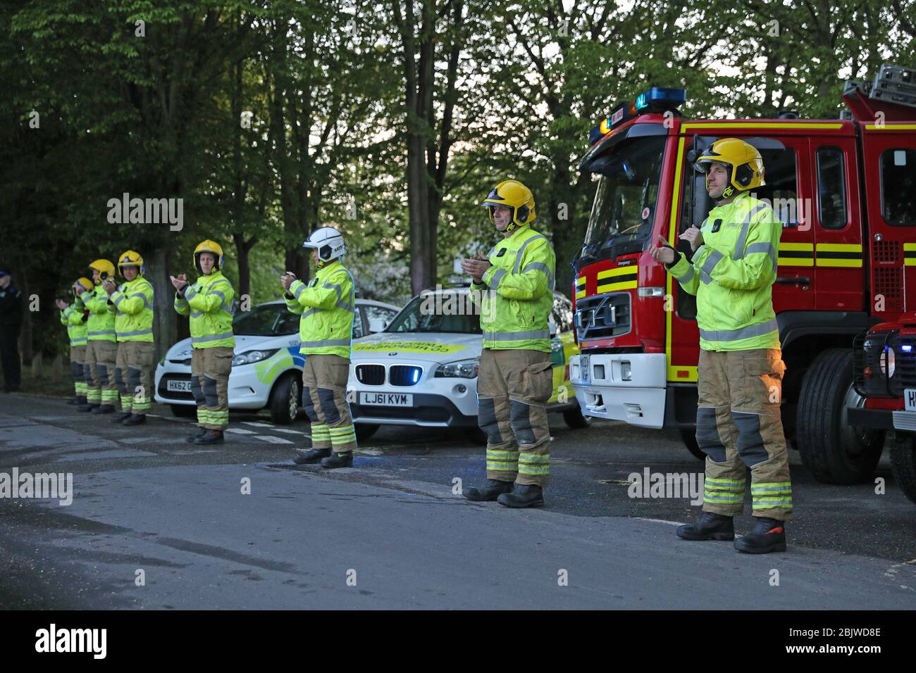 Members of the Hampshire Fire and Rescue Service in Hartley Wintney, near Basingstoke, join in the applause to salute local heroes during Thursday's nationwide Clap for Carers to recognise and support NHS workers and carers fighting the coronavirus pandemic. Stock Photo
