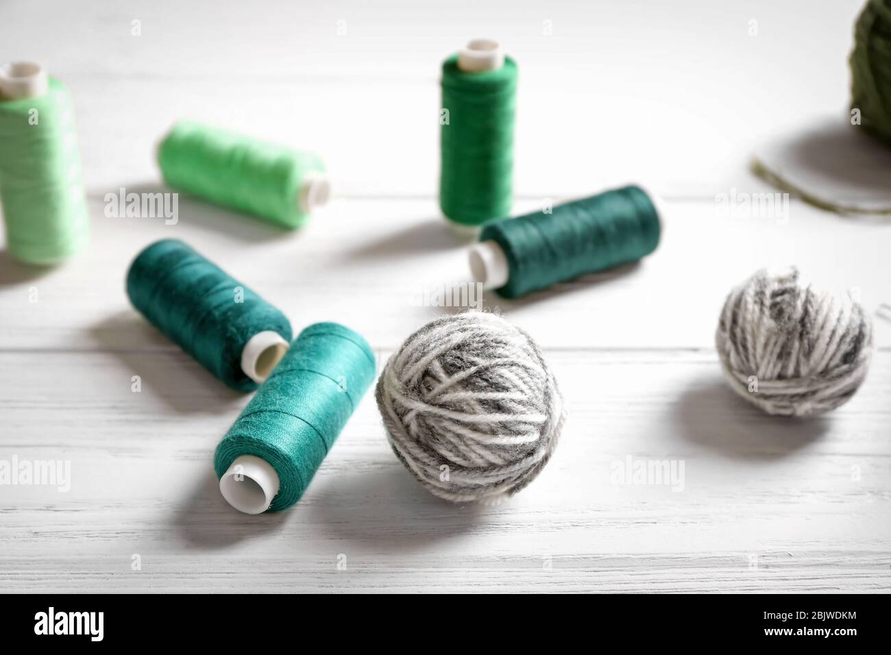 Sewing and woolen threads on wooden background Stock Photo - Alamy