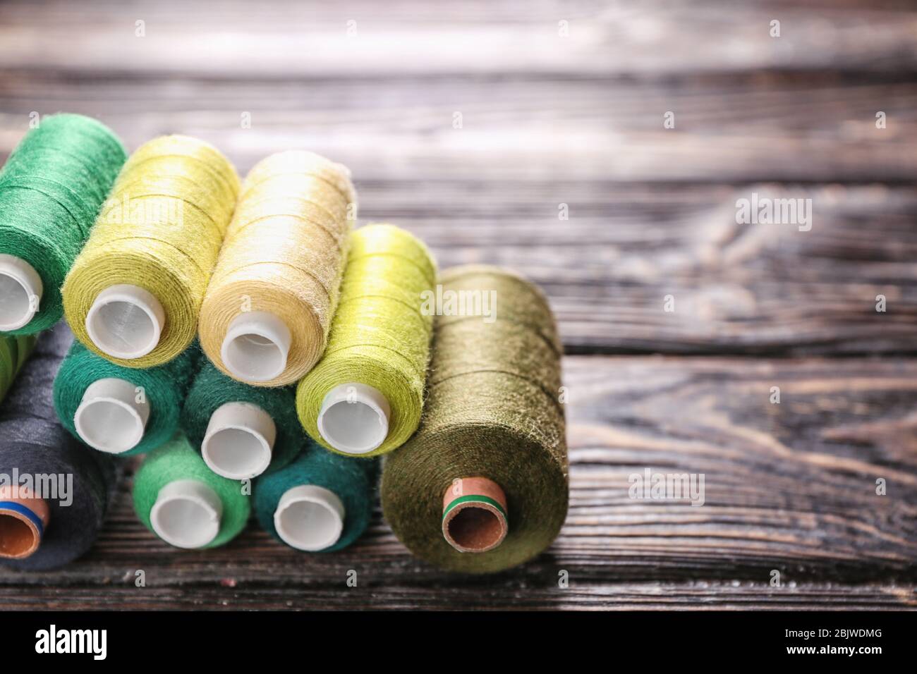 Set of color sewing threads on wooden background Stock Photo - Alamy