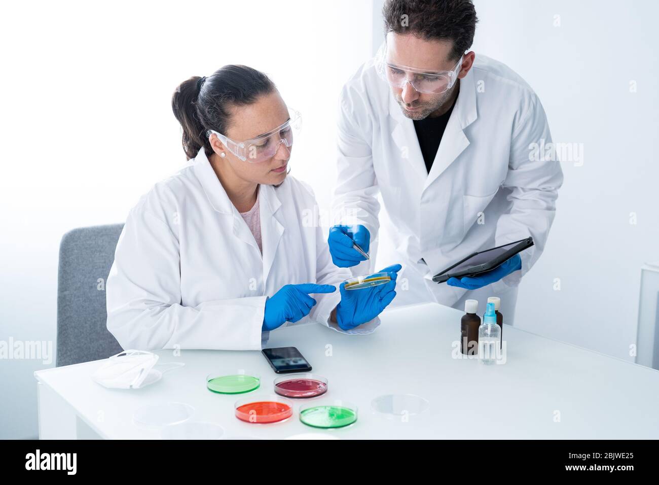 Young researchers or Scientists examining solution in petri dish at a laboratory. The researcher is analyzing the medicine related innovation. Biochem Stock Photo