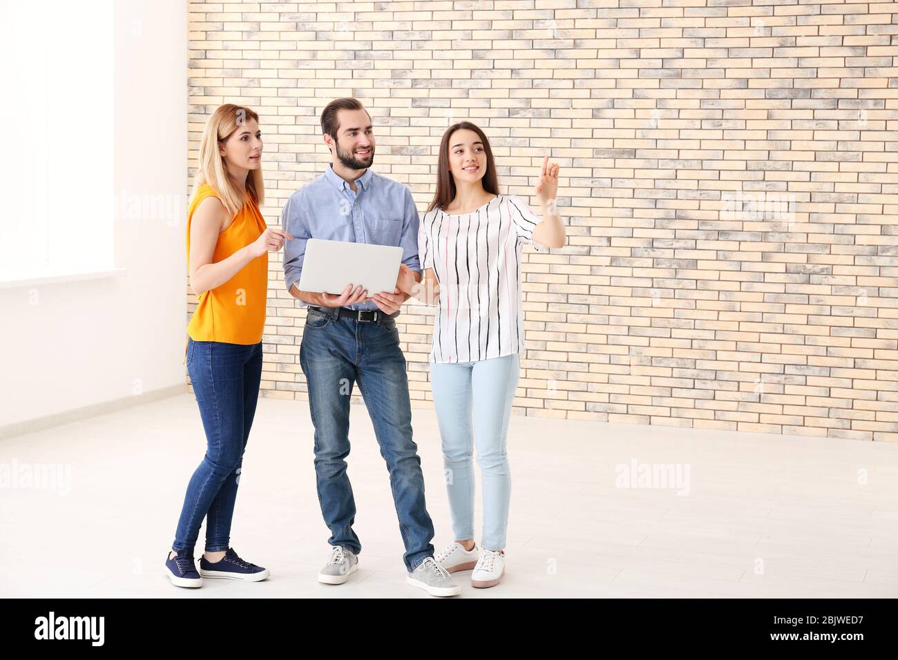 Real estate agent with trainee showing apartment to client Stock Photo