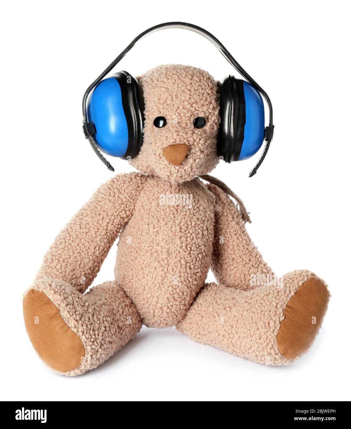 Toy bear with headphones on white background. Hearing protection Stock