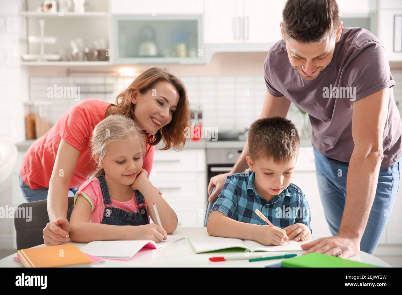 Little children with parents doing homework at home Stock Photo - Alamy