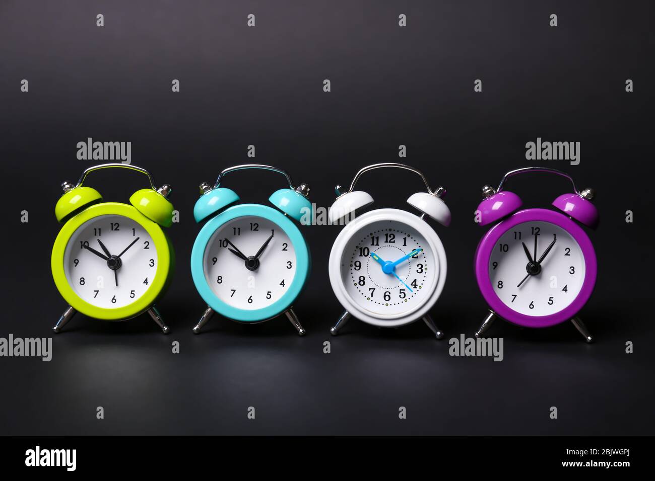 Different alarm clocks on black background Stock Photo Alamy