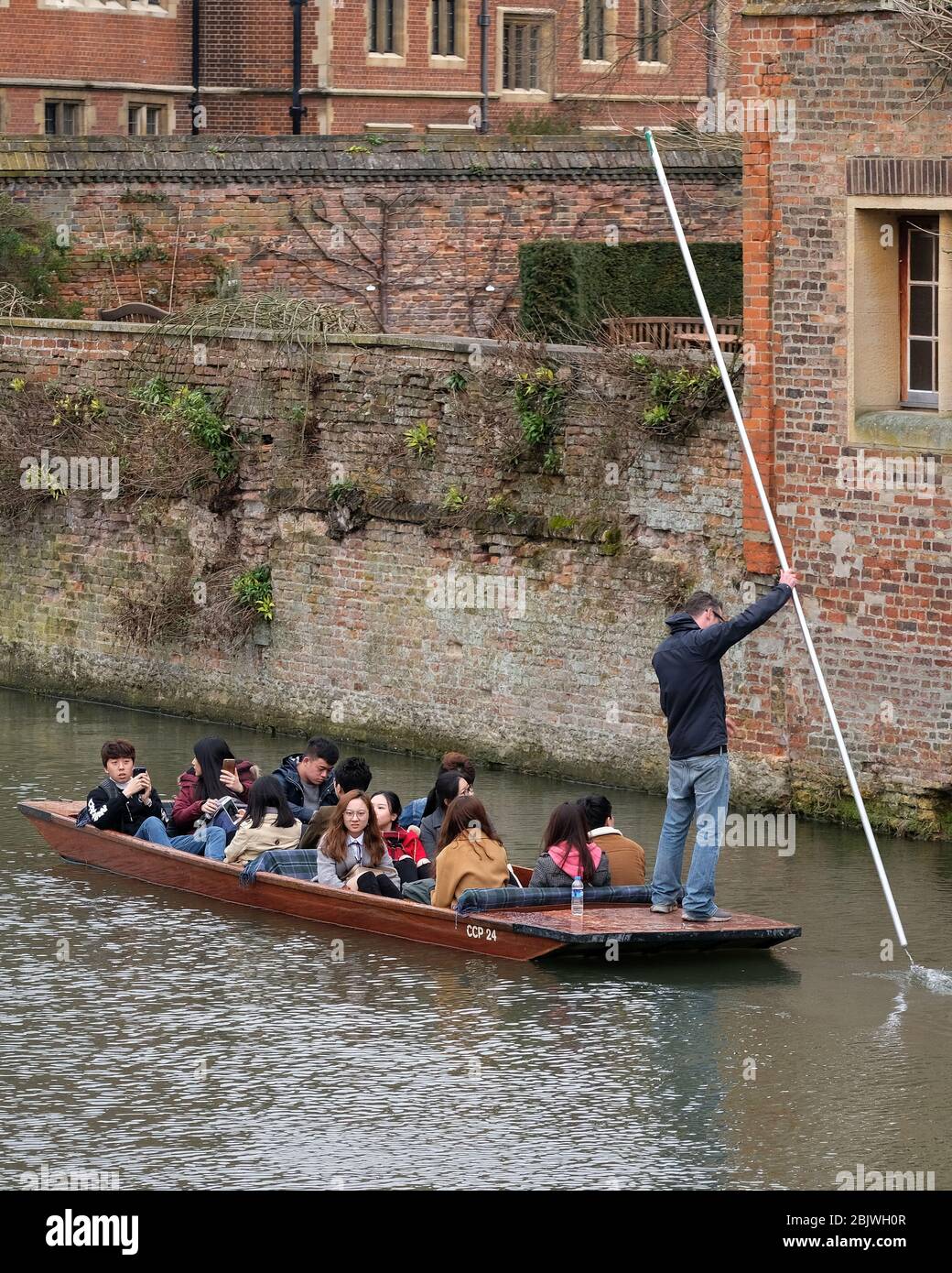 March 2018 - Japanese tourists being taken along  the river cam in a traditional wooden punt. Stock Photo