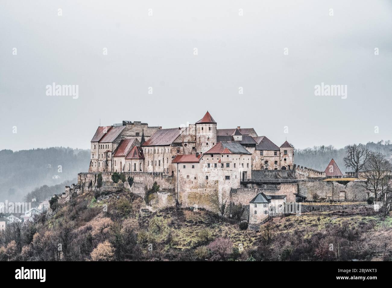 Burg zu Burghausen, castle complex on hill along river during rainy days in Burghausen, Germany Stock Photo