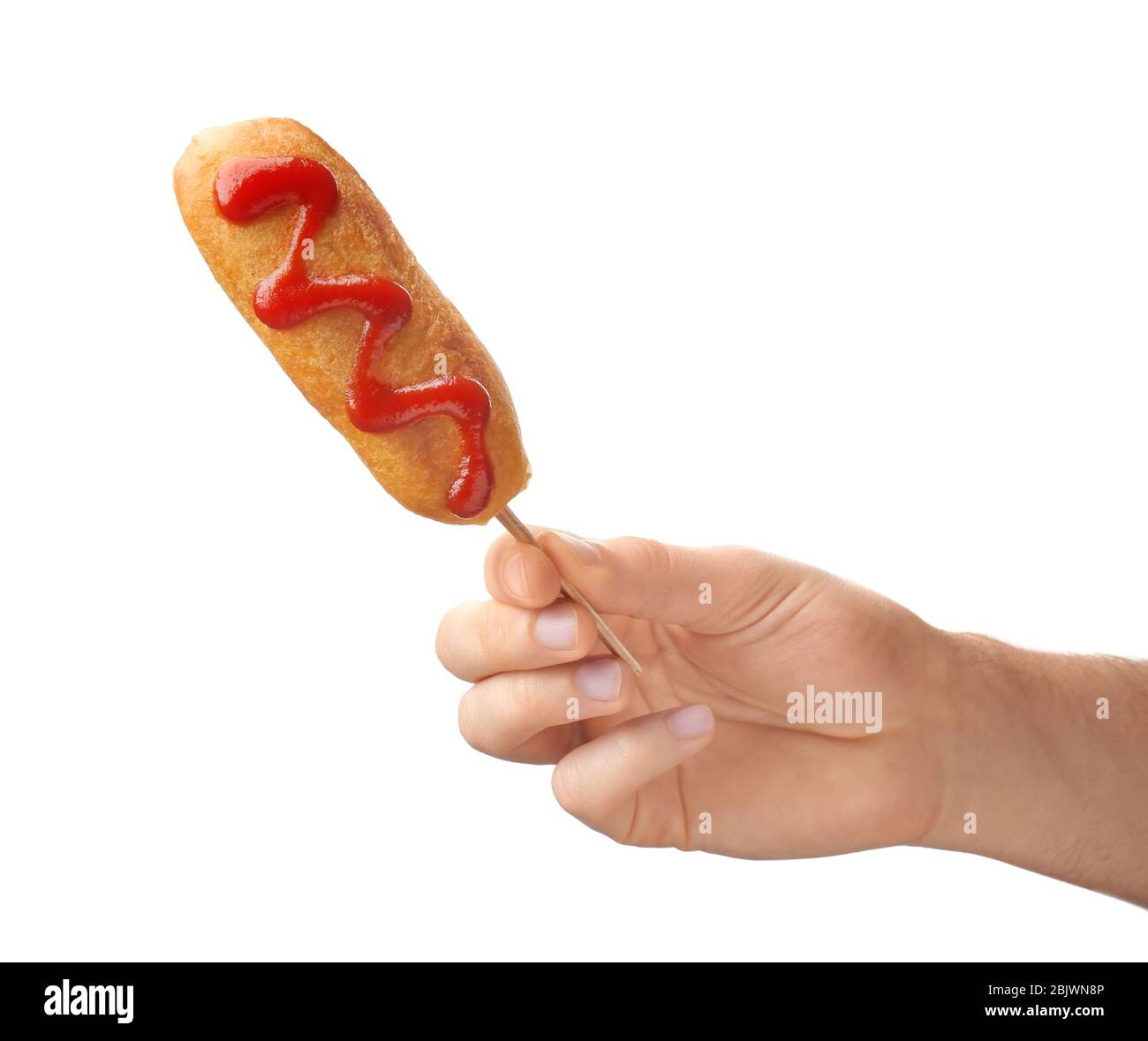 Woman holding tasty corn dog with ketchup on white background Stock Photo