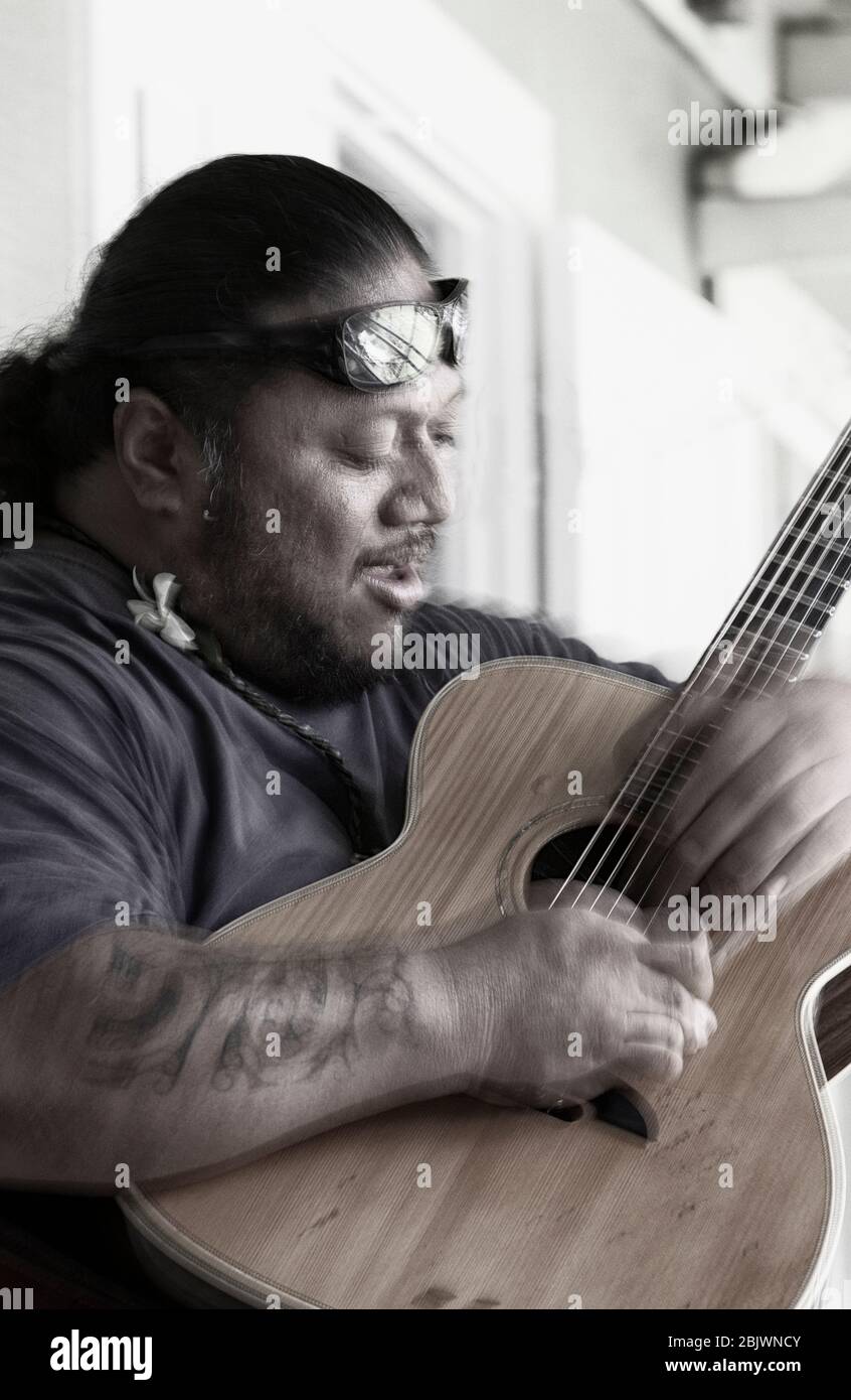 Pacific Islander (model released) plays slack key guitar in Hawaii. Stock Photo