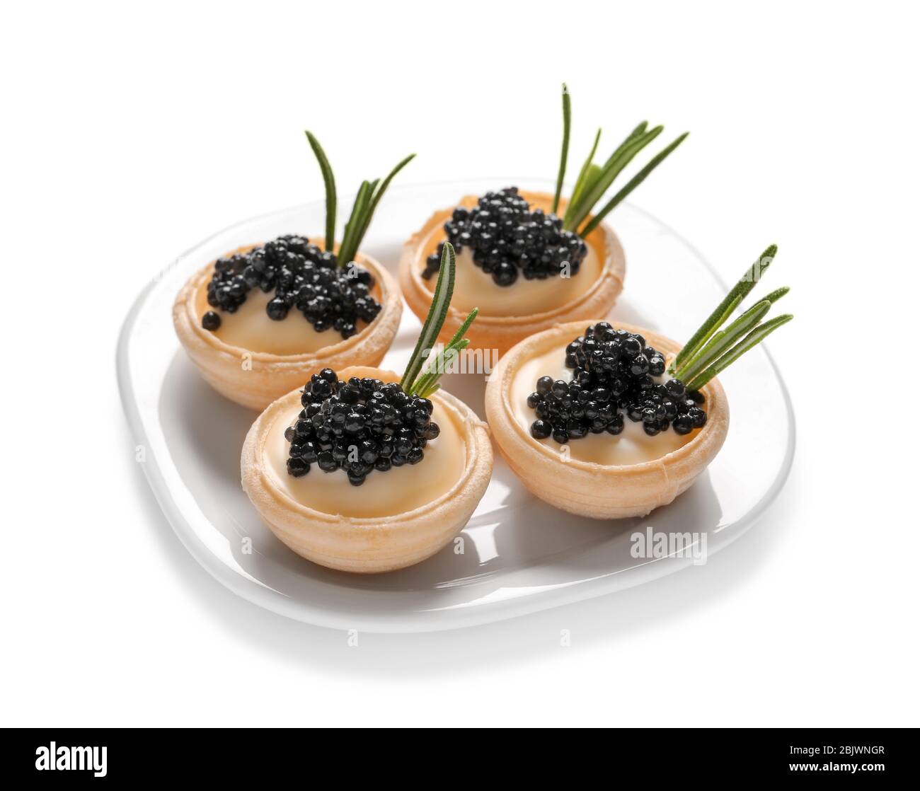 Plate of delicious canapes with black caviar on white background Stock Photo
