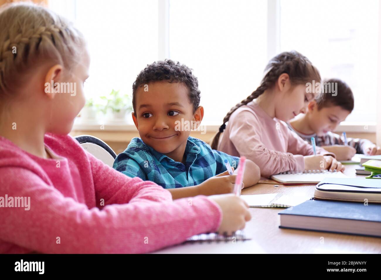 Cute children doing homework in classroom at school Stock Photo - Alamy