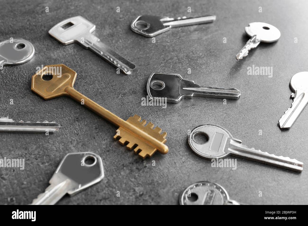 Keys and one different on grey background Stock Photo