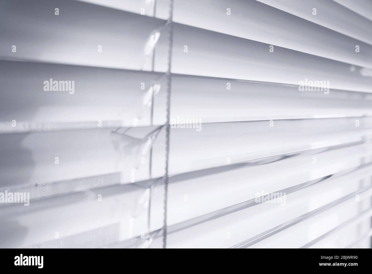 Modern white blinds on window, closeup Stock Photo