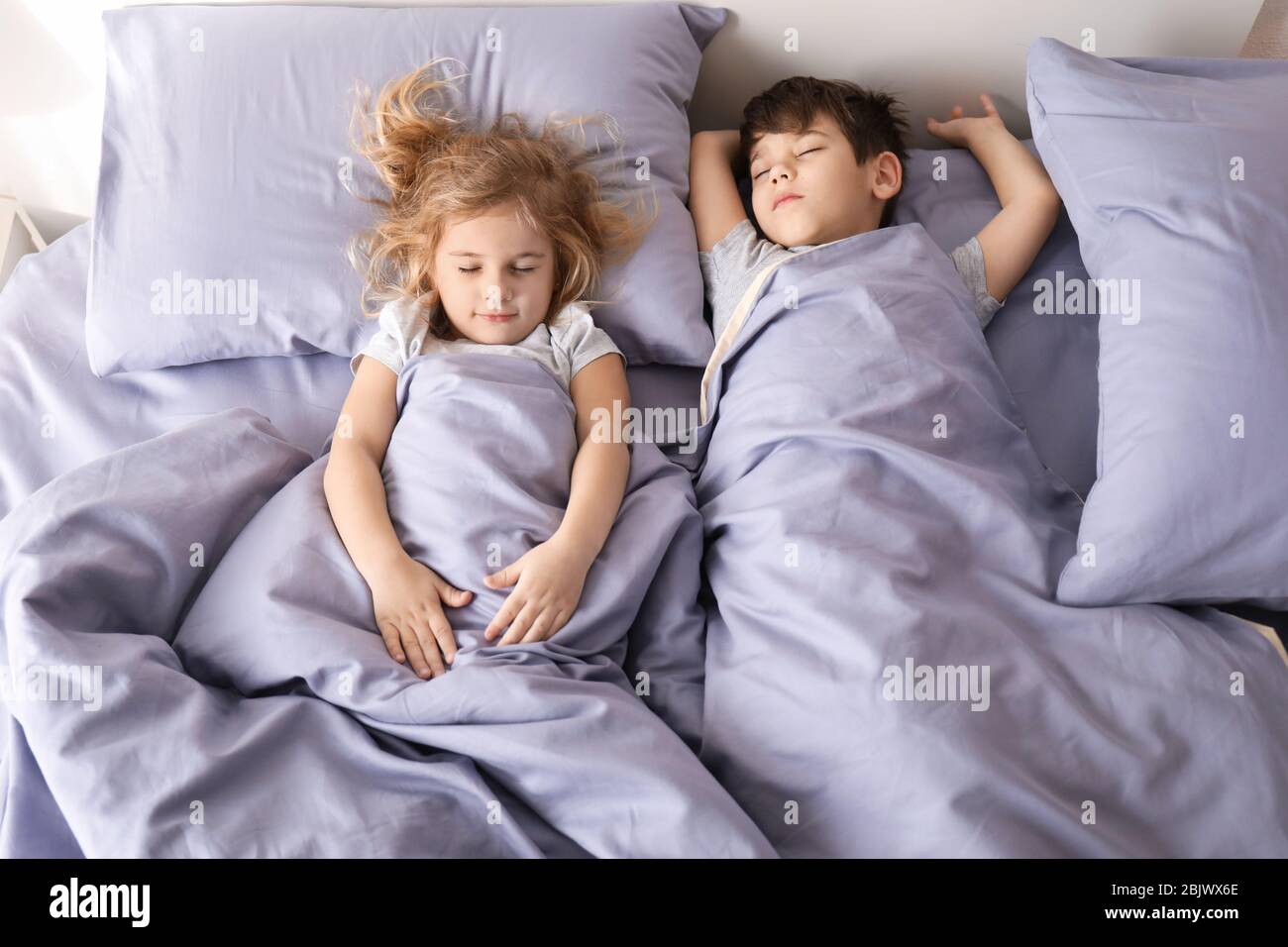 Cute little children sleeping in bed at home. Family bedtime Stock