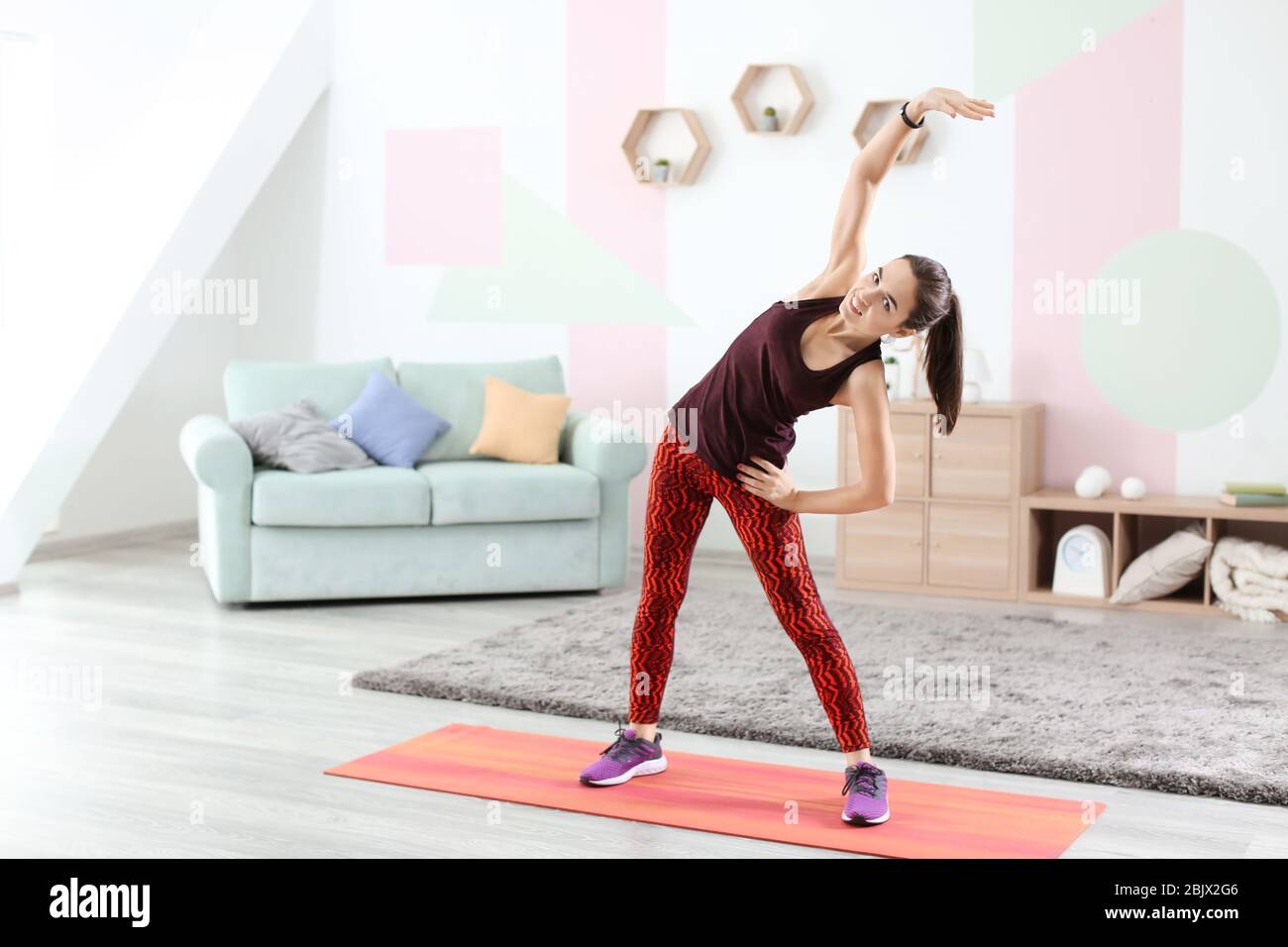 Beautiful young woman doing fitness exercise at home Stock Photo - Alamy