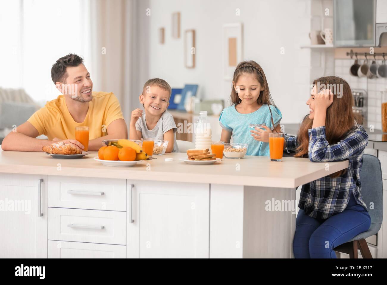 Happy family having breakfast in kitchen Stock Photo - Alamy