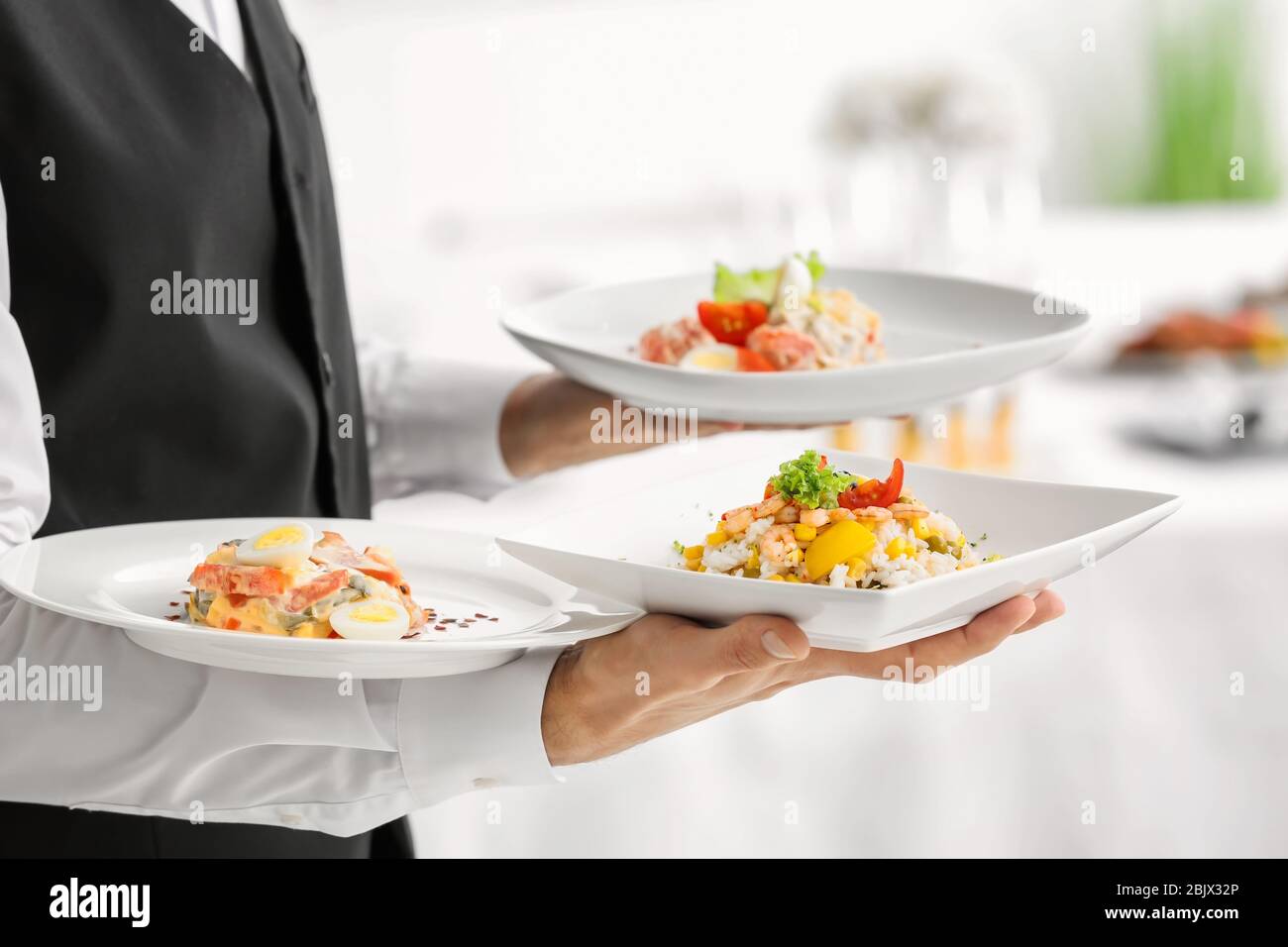 Waiter holding plates with dishes, closeup Stock Photo Alamy