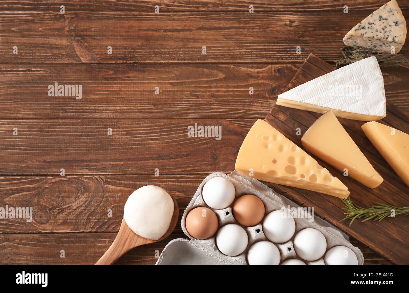 Swiss Cheese with Crumbs on a Wooden Surface and a Decorative Tablecloth  and Beautiful White Roses. Soft Focus. Stock Image - Image of cracks, blue:  190468939