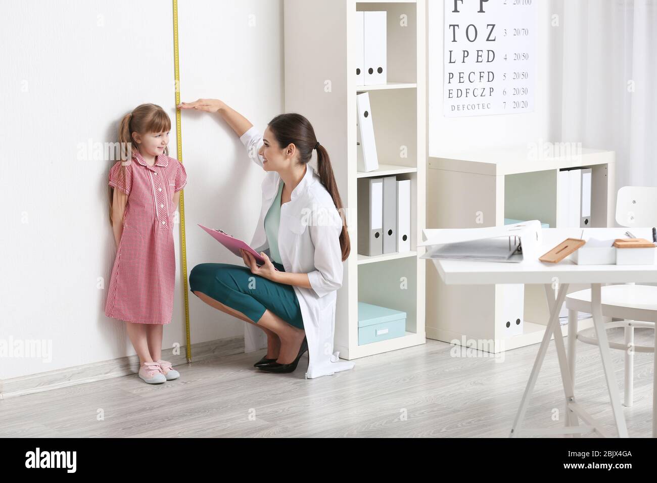 Doctor measuring height young girl hires stock photography and images