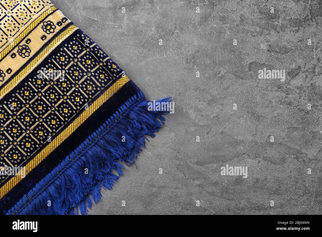 Muslim prayer rug on gray background Stock Photo - Alamy