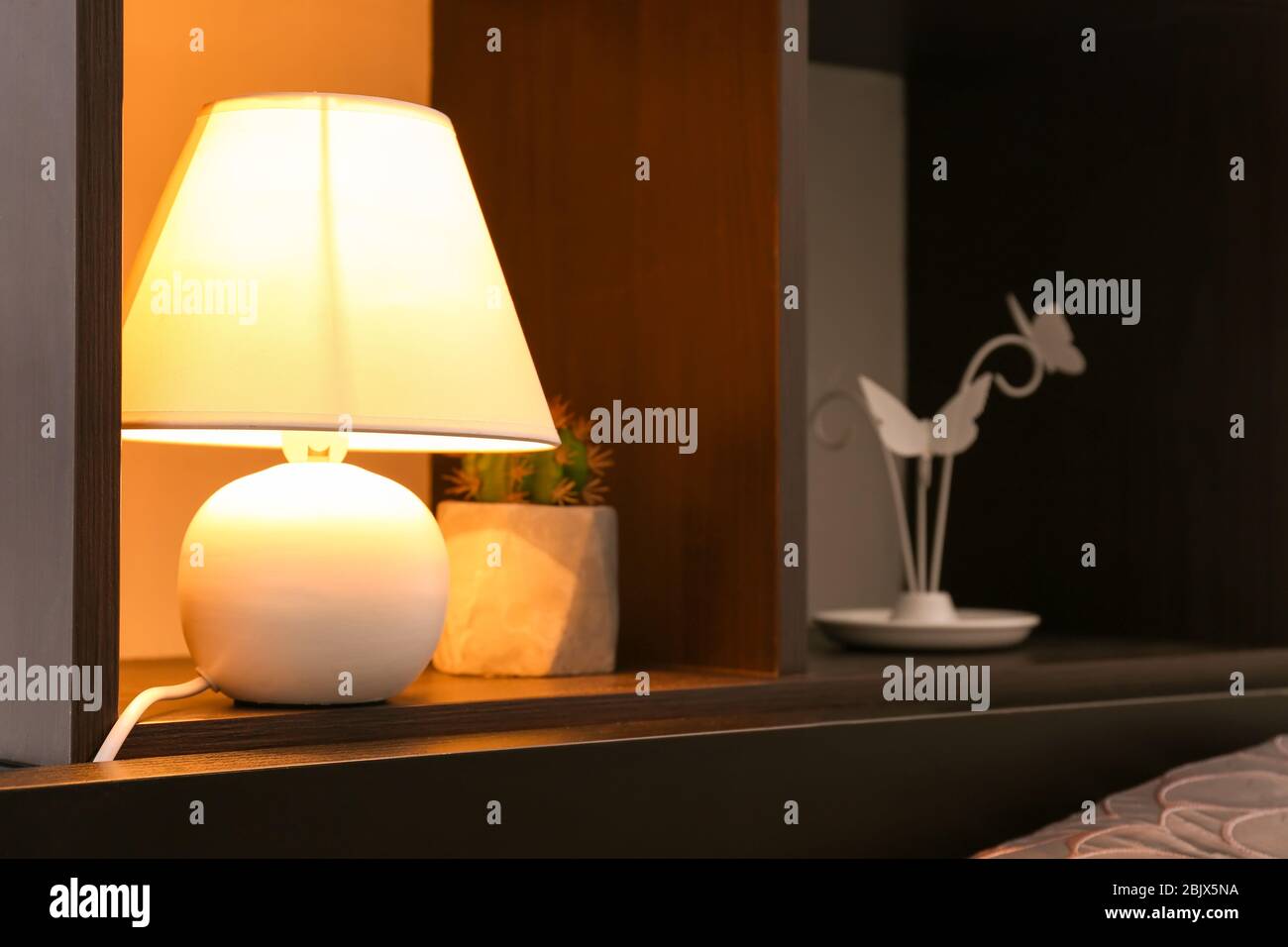 Shelving unit with elegant lamp in room Stock Photo Alamy