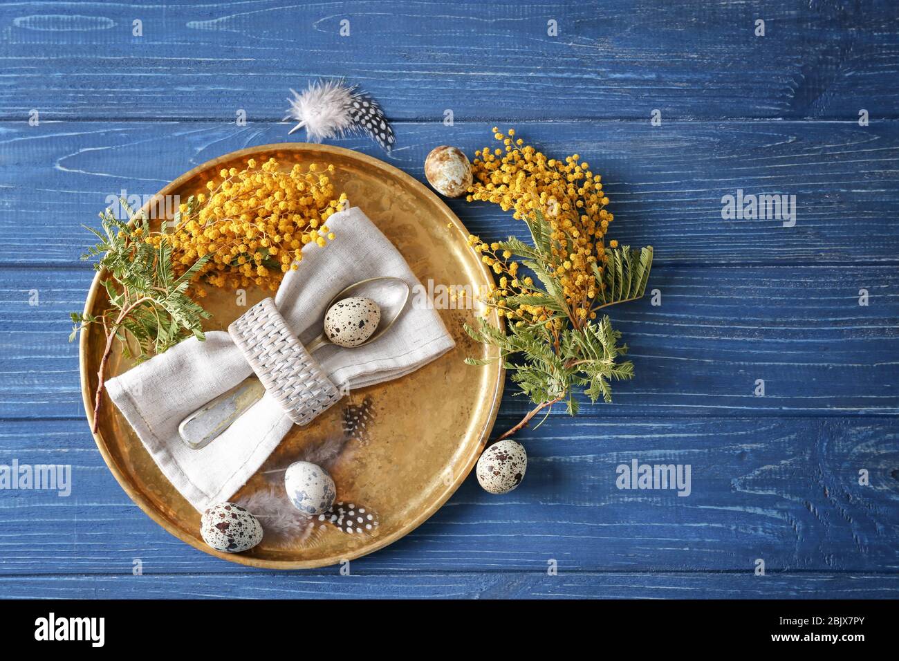 Beautiful festive Easter table setting with mimosa and quail eggs Stock Photo