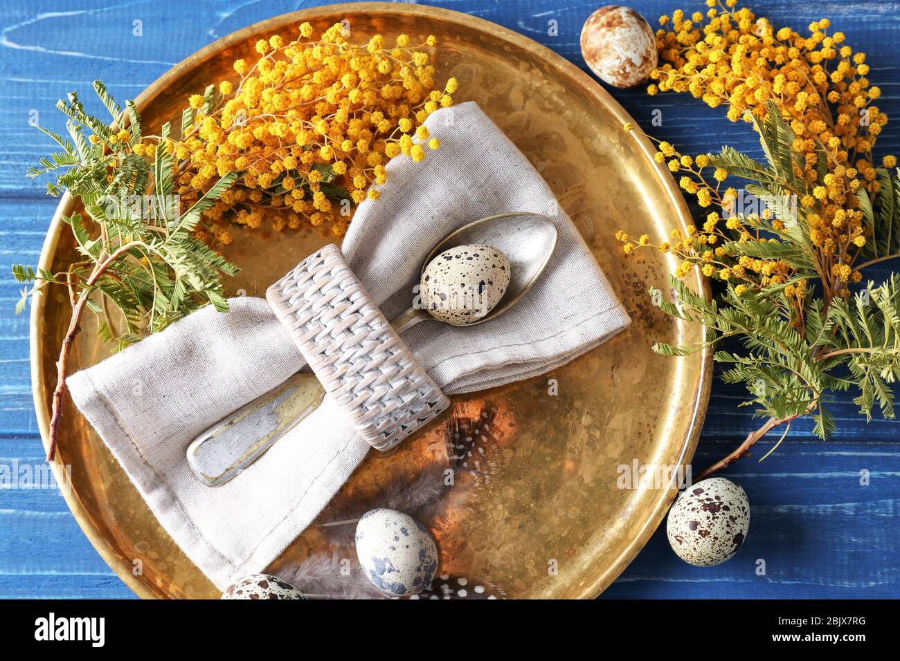 Beautiful festive Easter table setting with mimosa and quail eggs Stock Photo