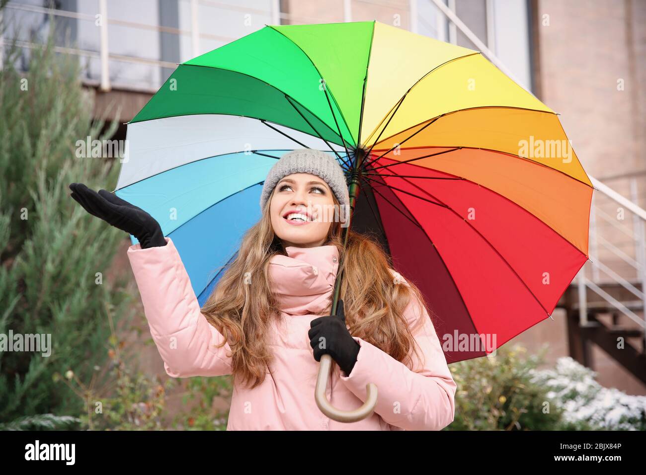 Young woman with rainbow umbrella outdoors Stock Photo