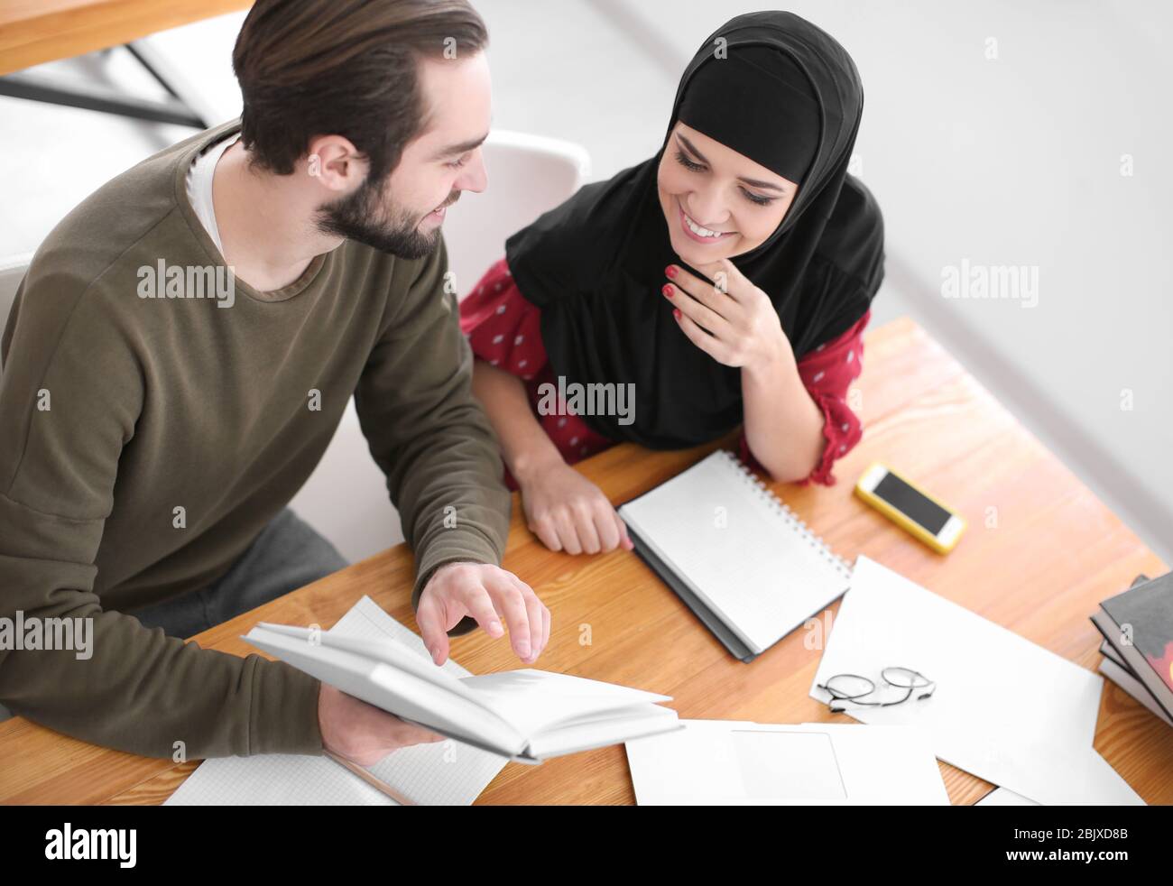 Male student and his Muslim classmate in library Stock Photo - Alamy