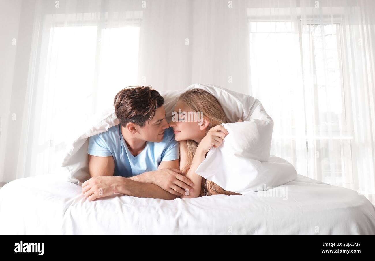 Young Couple Under Blanket In Bed At Home Stock Photo 355855051