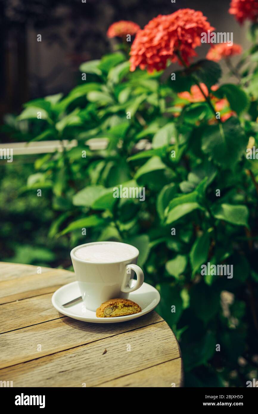 Cup of milk with flowers bouquet over wooden round table. Traditional healthy bio food concept. Stock Photo