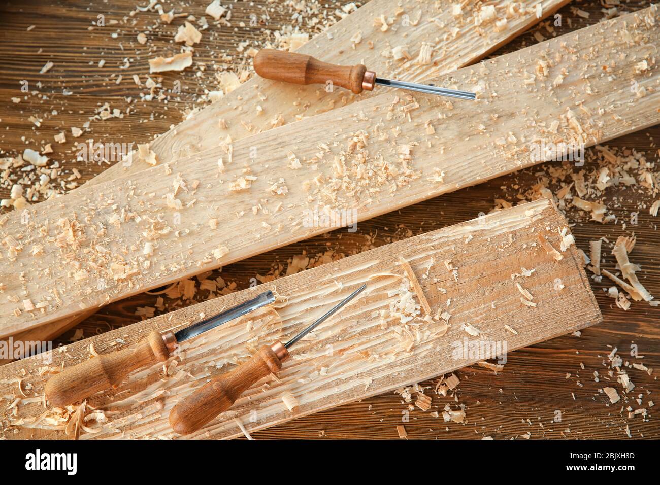 Chisels, wooden boards and sawdust in carpenter's Stock Photo