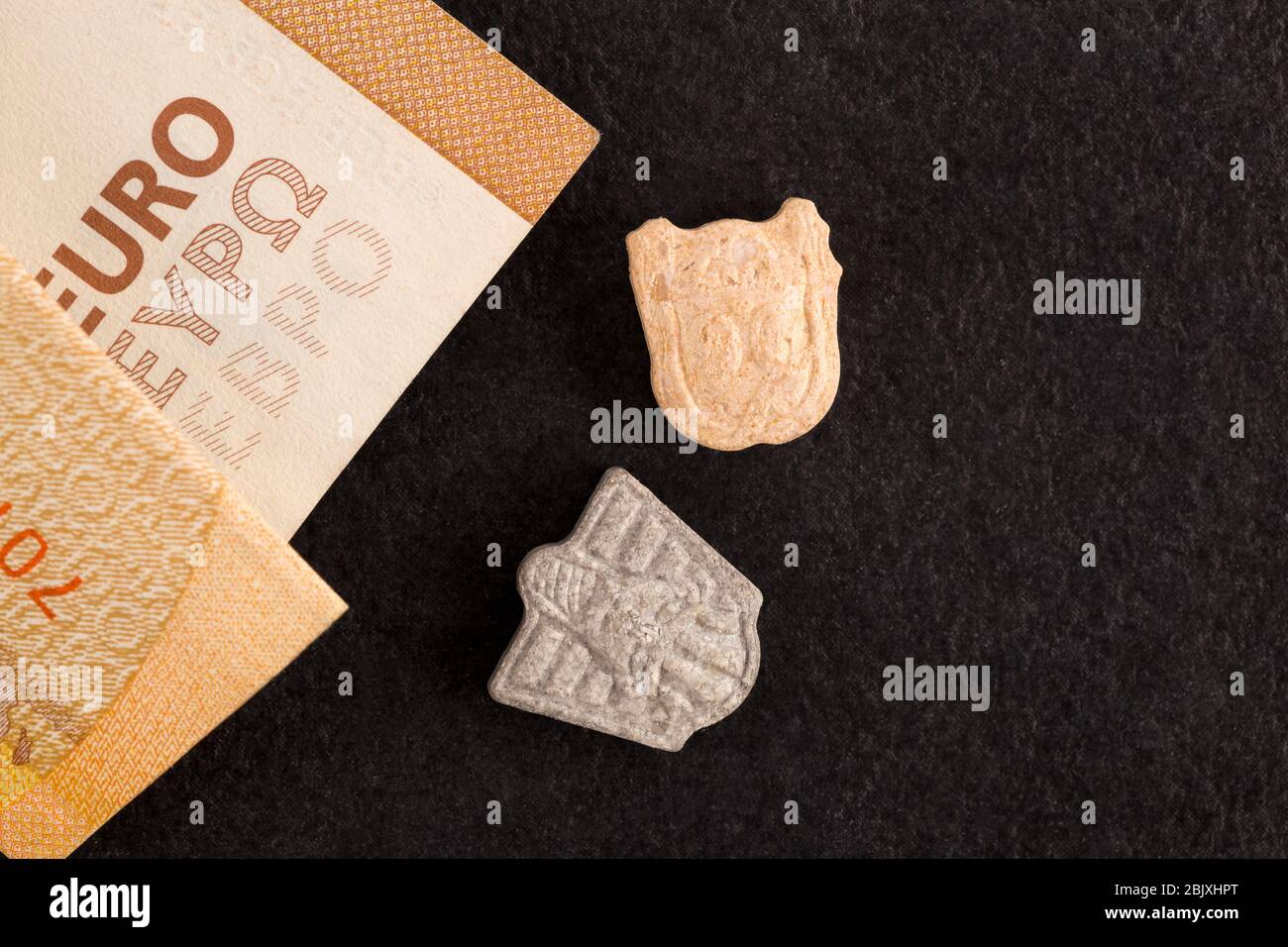 Detail of ecstasy lying on euro banknote. Drug dealing Stock Photo