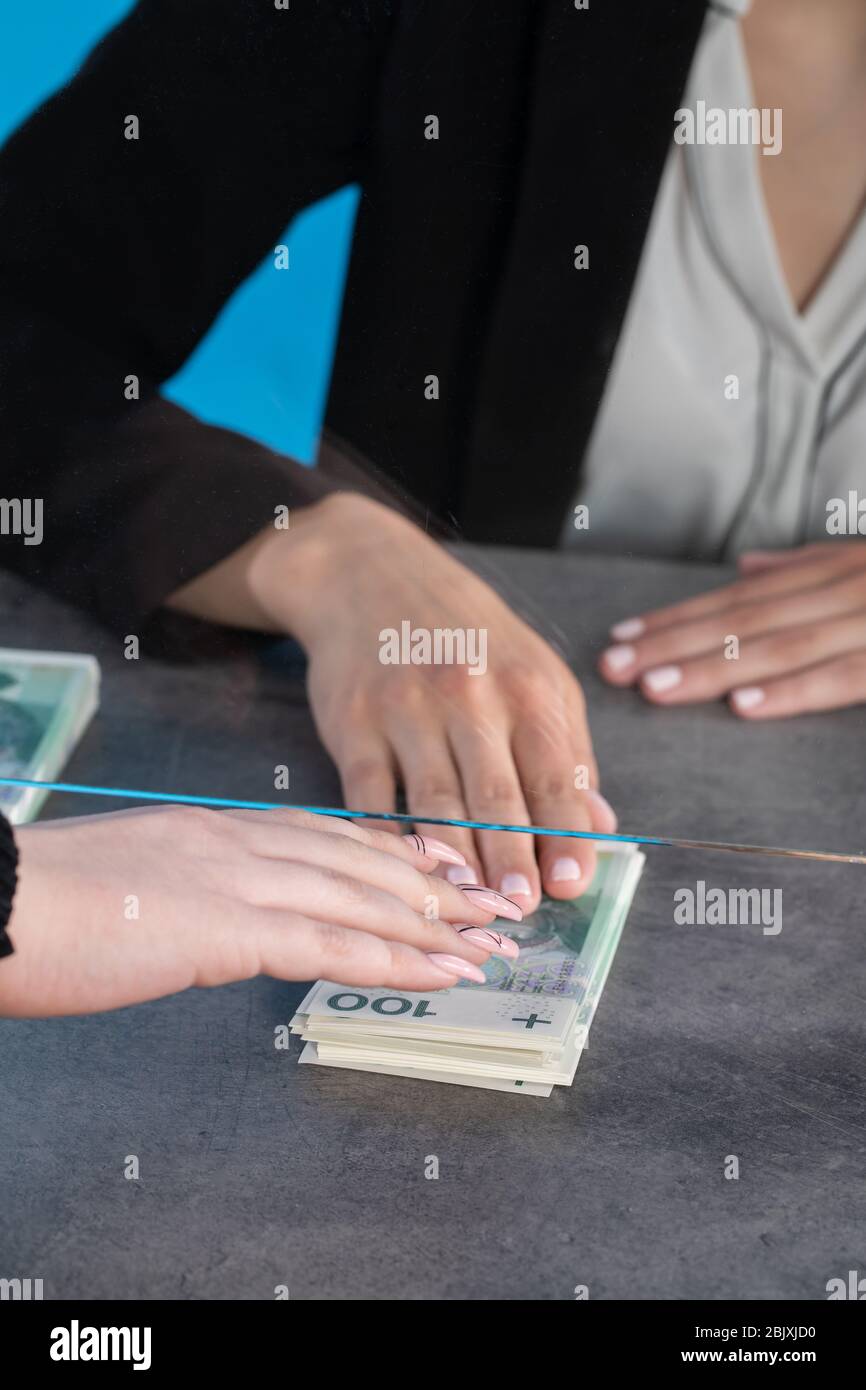 At a bank position, an employee accepts large sums of money from a ...