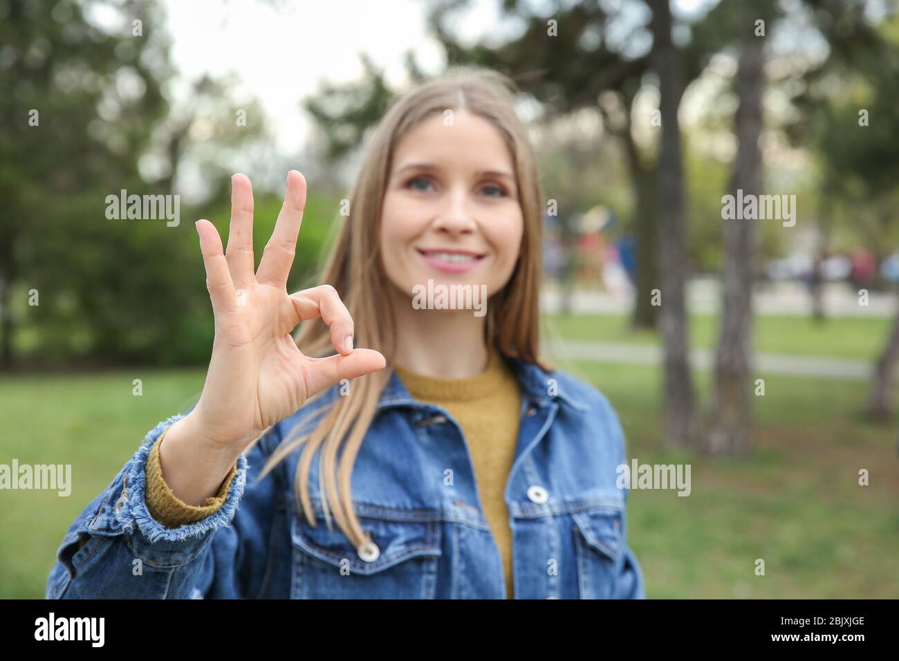 Young deaf mute woman using sign language outdoors Stock Photo Alamy