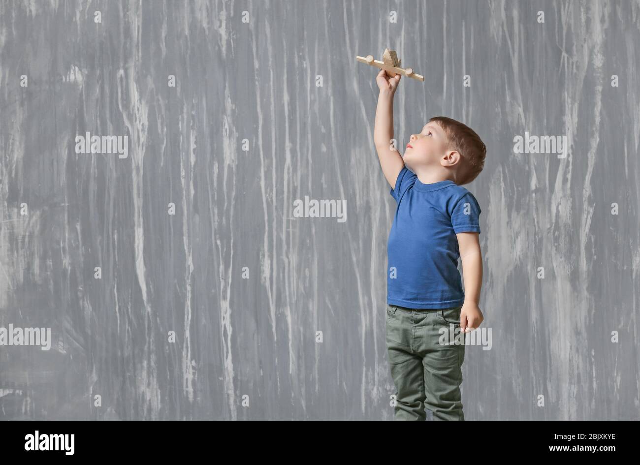 Little boy with autistic disorder playing with toy on grunge background Stock Photo