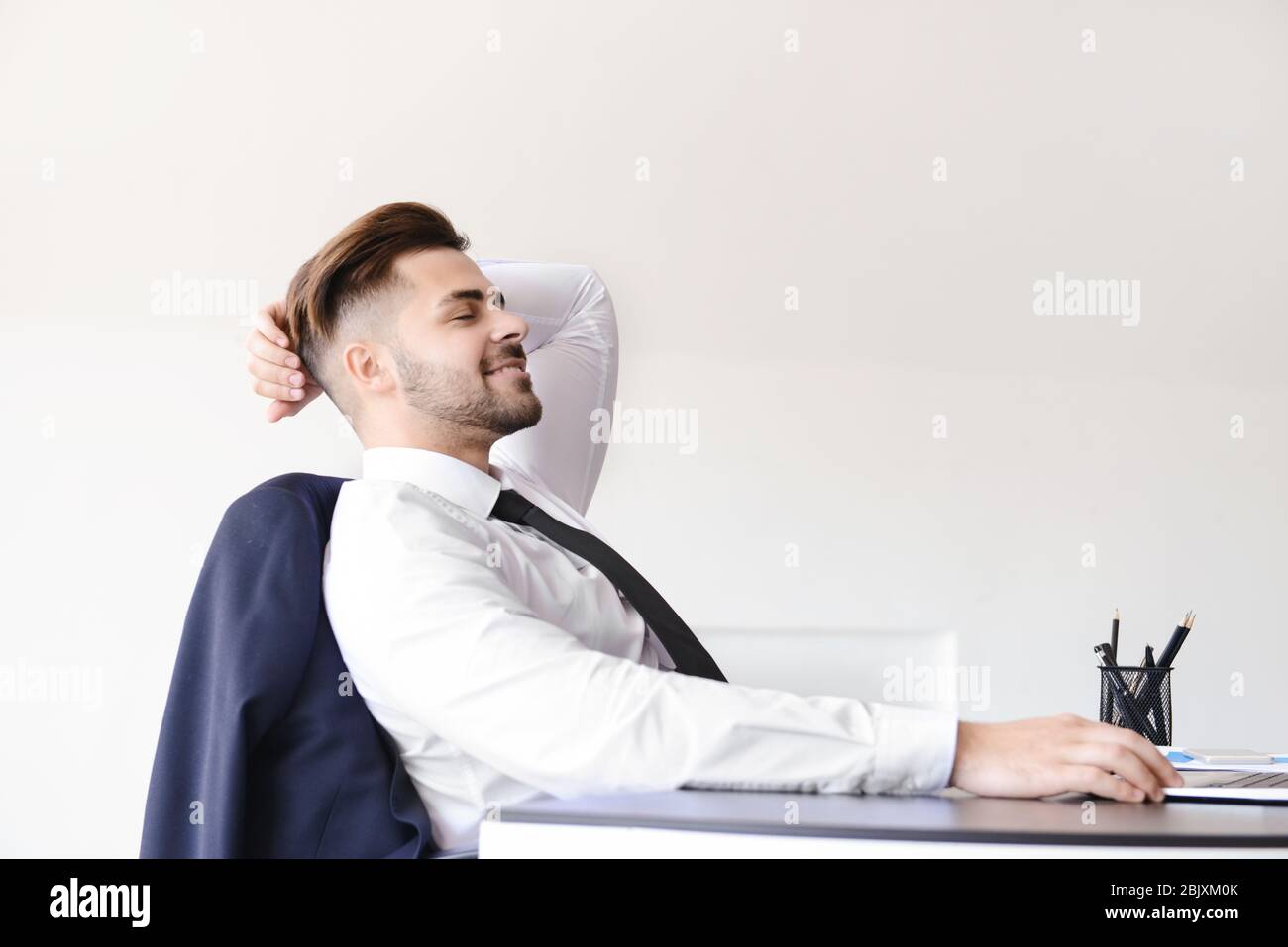 Handsome businessman having break during work in office Stock Photo