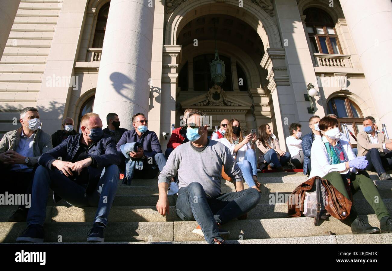 Belgrade, Serbia. 30th Apr 2020. Serbian opposition members wearing protective face masks sit in front of the House of Parliament during the protest, amid the ongoing coronavirus COVID-19 pandemic. Serbian opposition and members of Alliance for Serbia protested in front of the parliament building against government policies to stem the spread of the pandemic COVID-19 disease caused by the SARS-CoV-2 coronavirus. Credit: Koca Sulejmanovic/Alamy Live News Stock Photo