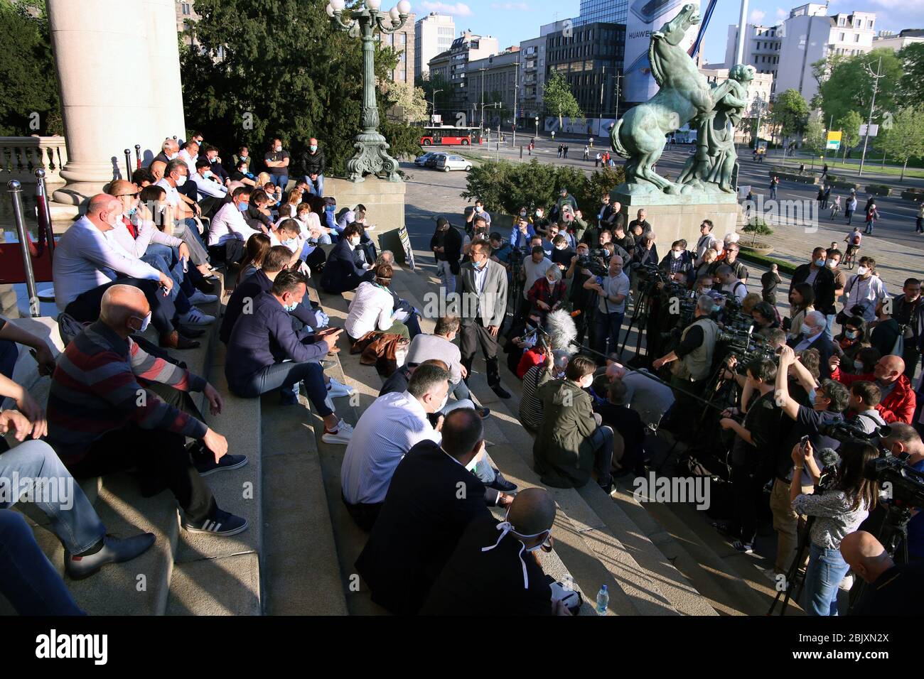 Belgrade, Serbia. 30th Apr 2020. Serbian opposition members wearing protective face masks sit in front of the House of Parliament during the protest, amid the ongoing coronavirus COVID-19 pandemic. Serbian opposition and members of Alliance for Serbia protested in front of the parliament building against government policies to stem the spread of the pandemic COVID-19 disease caused by the SARS-CoV-2 coronavirus. Credit: Koca Sulejmanovic/Alamy Live News Stock Photo