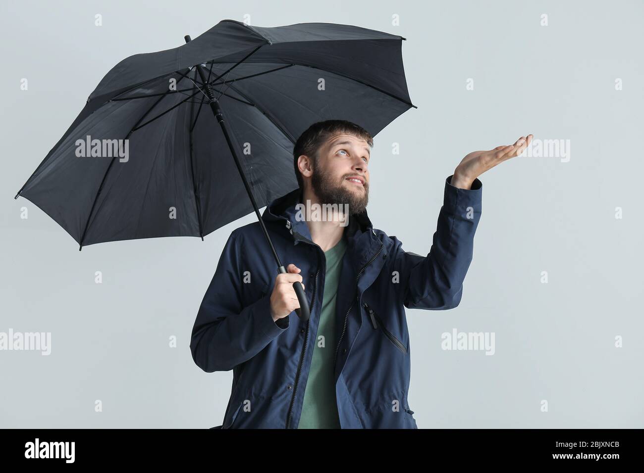 Handsome man with umbrella on white background Stock Photo - Alamy