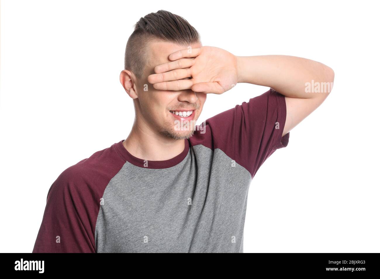 Young man covering his eyes on white background Stock Photo - Alamy