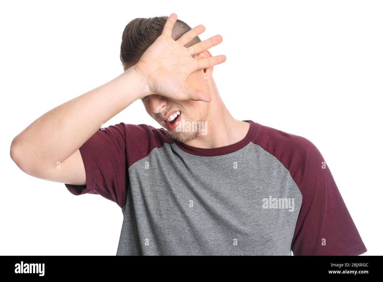 Young man covering his eyes on white background Stock Photo - Alamy